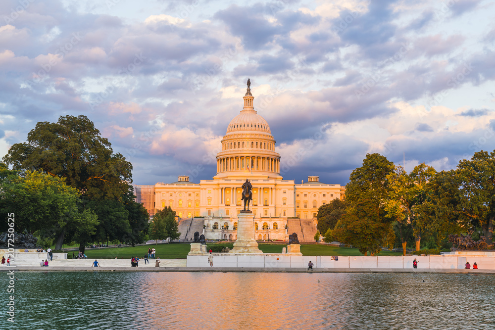 Obraz premium The United States Capitol building at sunset wirh reflection in water.