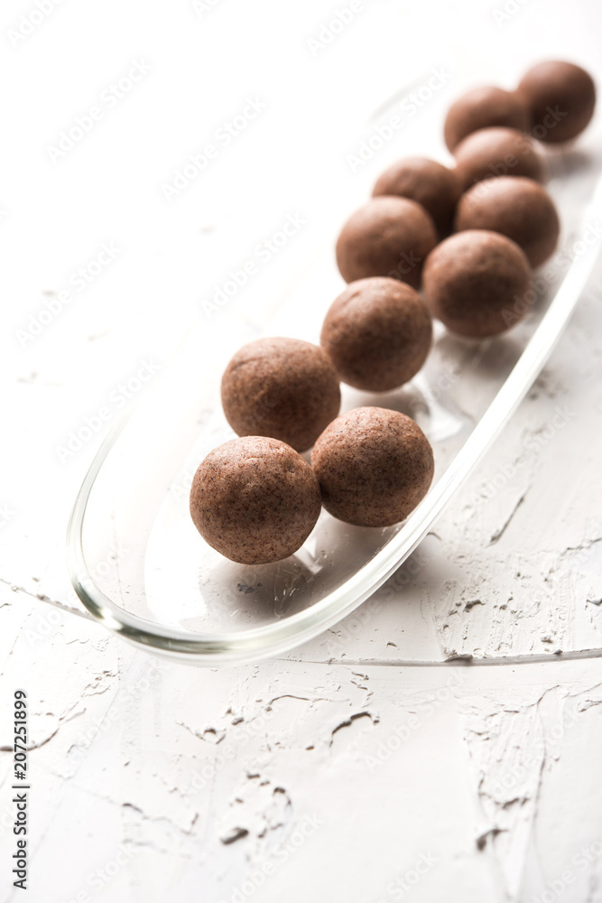 Nachni laddu or Ragi laddoo or balls made using finger millet, sugar and ghee. It's a healthy food from India. Served in a bowl or plate over moody background. Selective focus Nachni laddu or Ragi laddoo or balls made using finger millet, sugar and ghee. It's a healthy food from India. Served in a bowl or plate over moody background. Selective focus