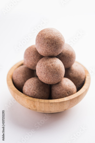 Nachni laddu or Ragi laddoo or balls made using  finger millet  sugar and ghee. It s a healthy food from India. Served in a bowl or plate over moody background. Selective focus