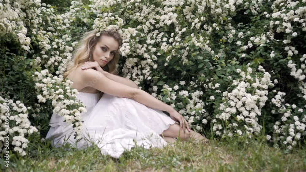 Girl and blooming cherry. The girl is siting lifestyle in nature blossoming garden cherry Girl and blooming cherry. The girl is siting lifestyle in nature blossoming garden cherry