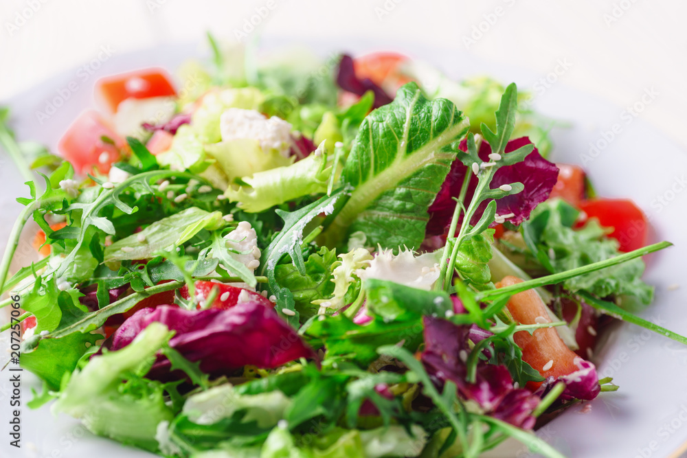 Fresh organic super food salad on white plate with fork on side Fresh organic super food salad on white plate with fork on side