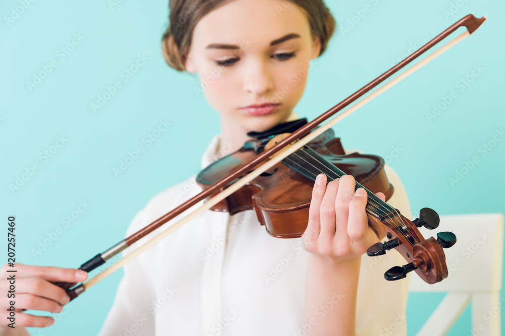 beautiful girl playing violin, isolated on blue beautiful girl playing violin, isolated on blue