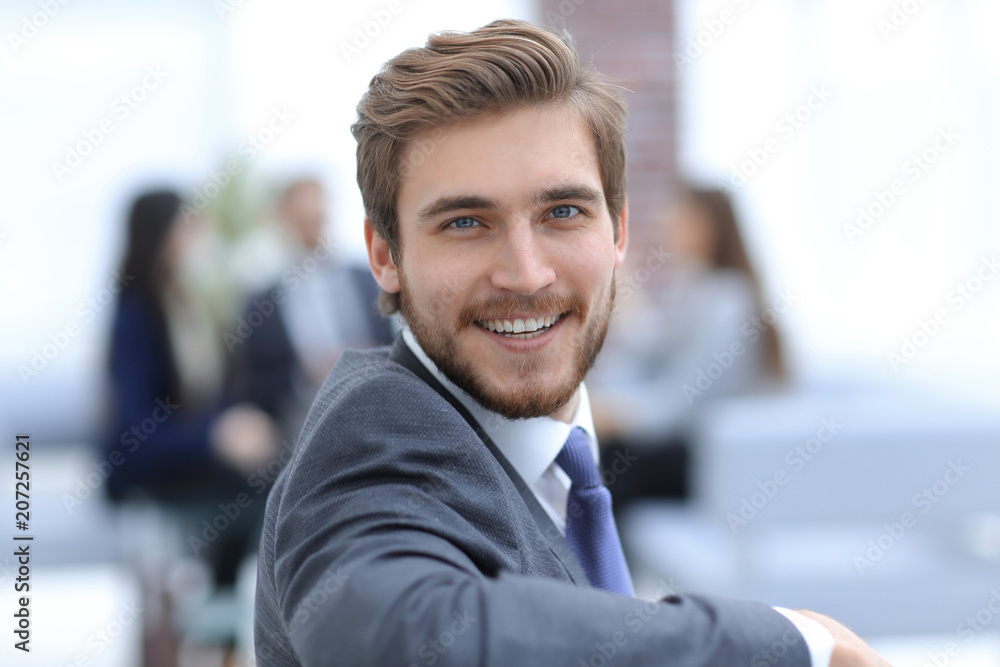 Successful business man standing with his staff in background at Successful business man standing with his staff in background at