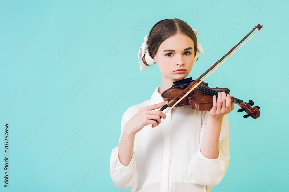 stylish teen girl playing violin, isolated on blue stylish teen girl playing violin, isolated on blue
