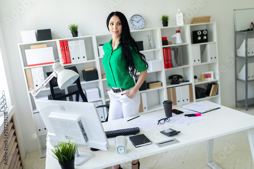 A young girl stands near an office desk. © Ivan Traimak