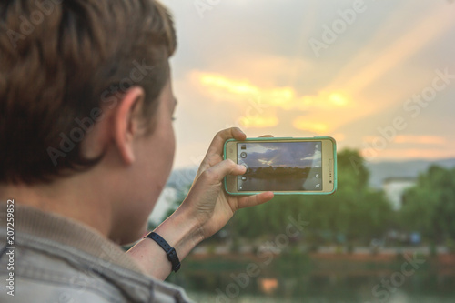 Tourist taking picture of beautiful sunset