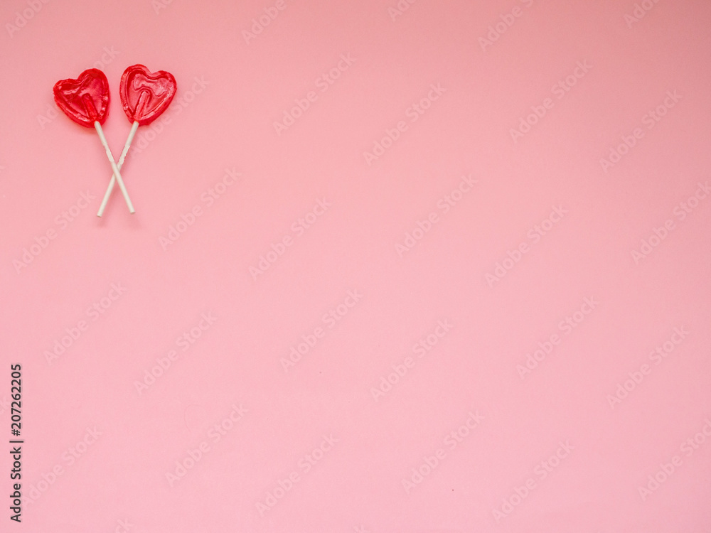 Two red heart lollipop on  pink background with copy space
