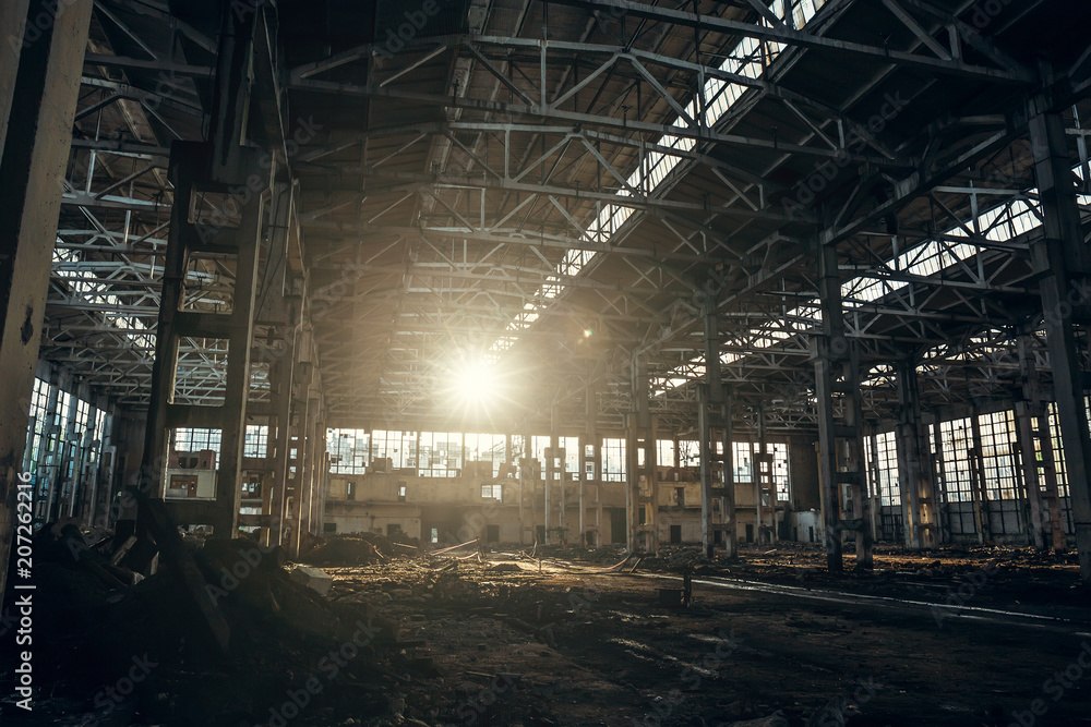 Abandoned industrial creepy warehouse inside old dark grunge factory building in sunlight