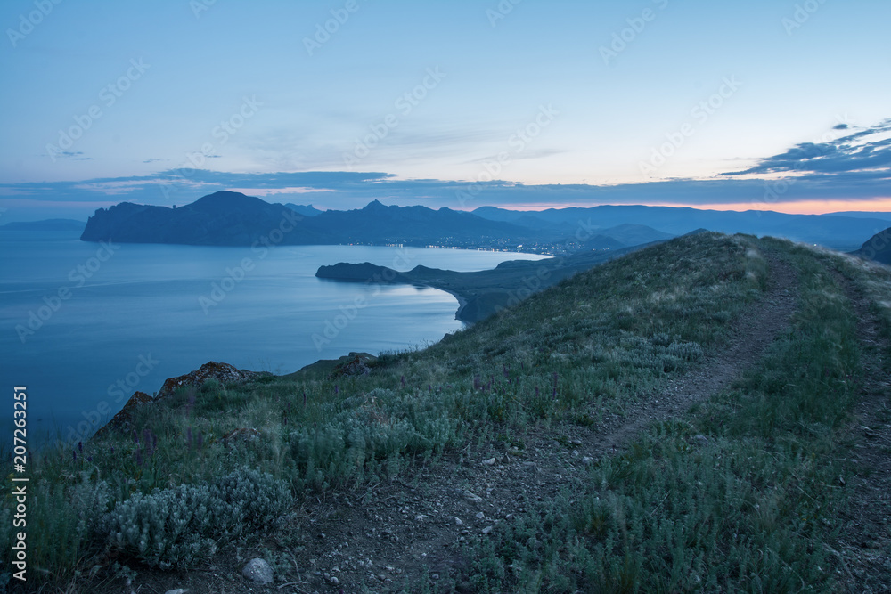 the road leading to the city through the mountains. evening landscape after sunset