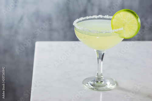 Chilled Margarita Served Straight Up in a Goblet with Salted Rim on Marble Bar