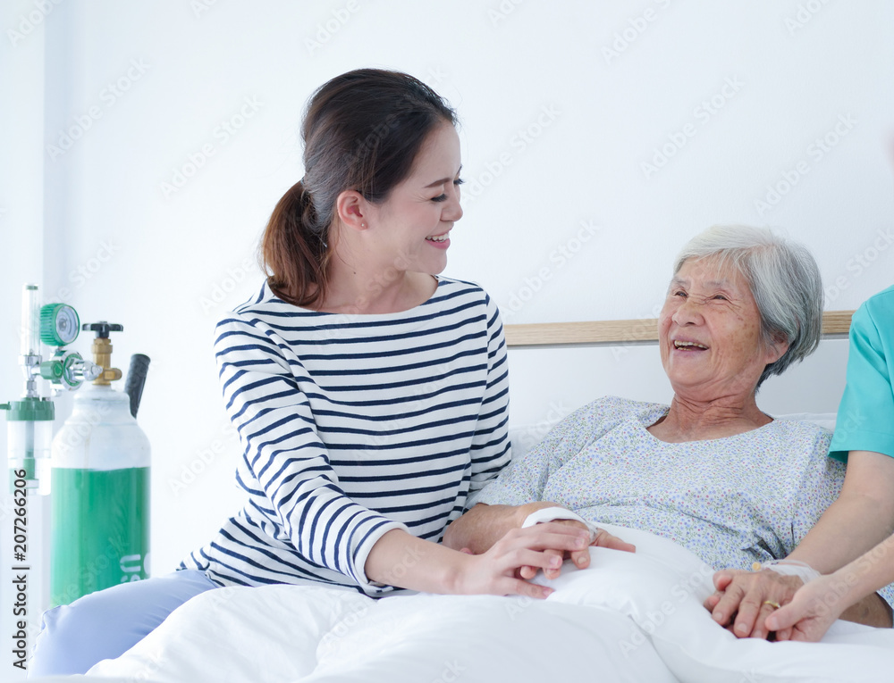 Happy Elderly woman talking with Senior nurse and her daughter in hospital room. Happy Elderly woman talking with Senior nurse and her daughter in hospital room.
