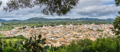 Mallorca, XXL panoramic view through natural window of green plants over ancient city of Arta photo