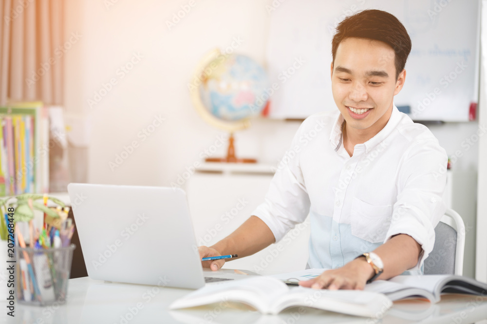 Young Asian man university student working with laptop computer. Young Asian man university student working with laptop computer.