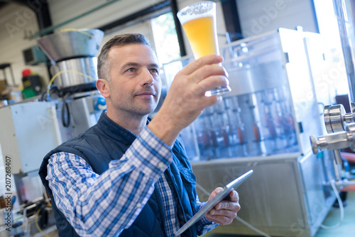 Photography brewer inspecting the beer