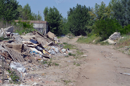A rural road passes between garbage hills. Ecology of Ukraine. Nature near Ukrainian capital.Environmental contamination. Illegal junk dump.
