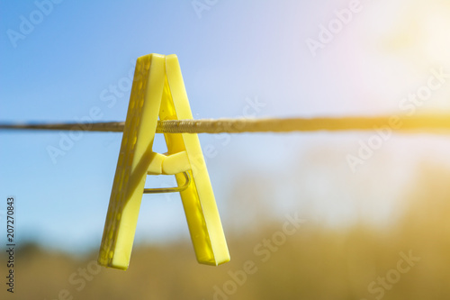 clothespin on a rope holds clothes. the letter A