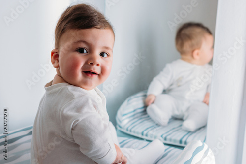 Portrait of smiling baby boy sitting on mat photo