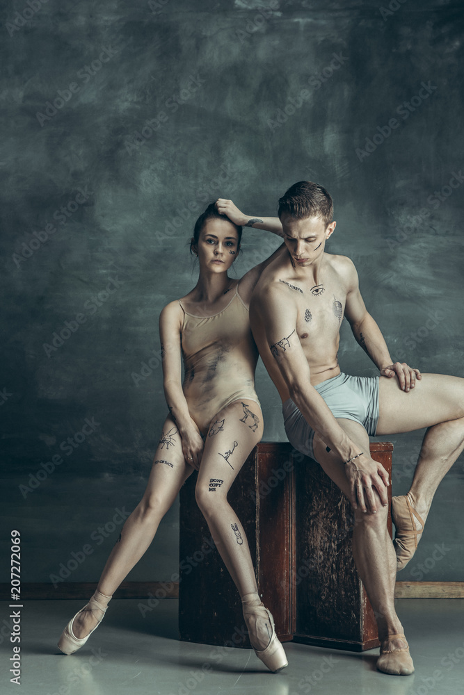 The young modern ballet dancers posing on gray studio background