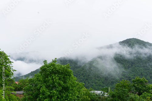 Fog moving over green mountain