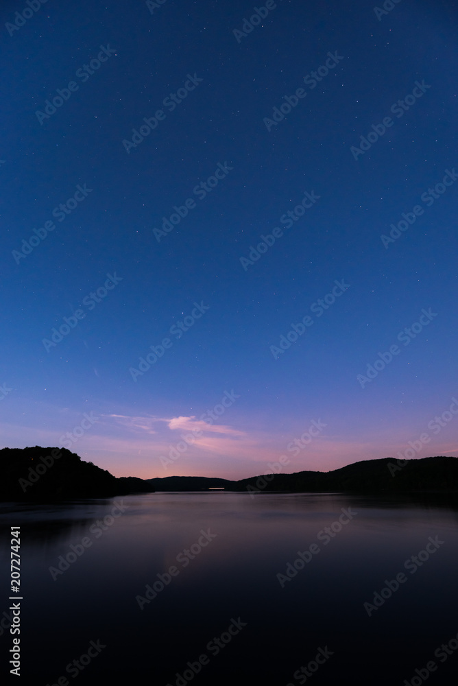 Stars over water with reflection in late evening Stars over water with reflection in late evening