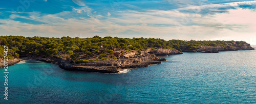 Mediterranean coastal landscape. Mallorca, Spain. Blue sea and green trees. Clear sky