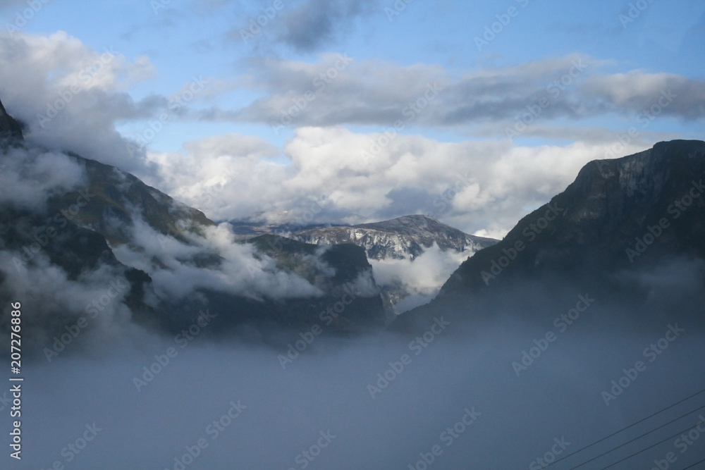 Mountain view is surrounded by clouds