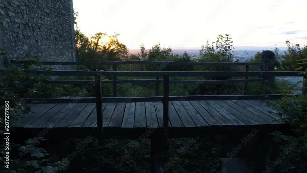close flight over wood bridge at ruin at sunset