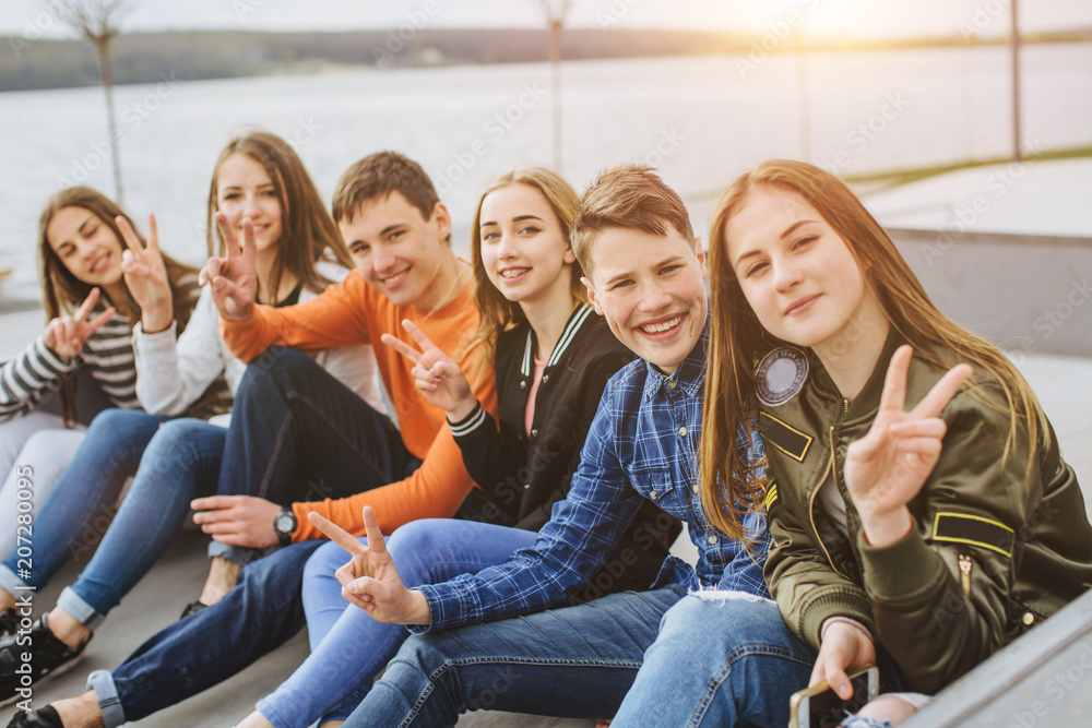 Obraz premium Letnie wakacje i nastoletnie pojęcie - grupa uśmiechniętych nastolatków z deskorolka wychodzić na zewnątrz.