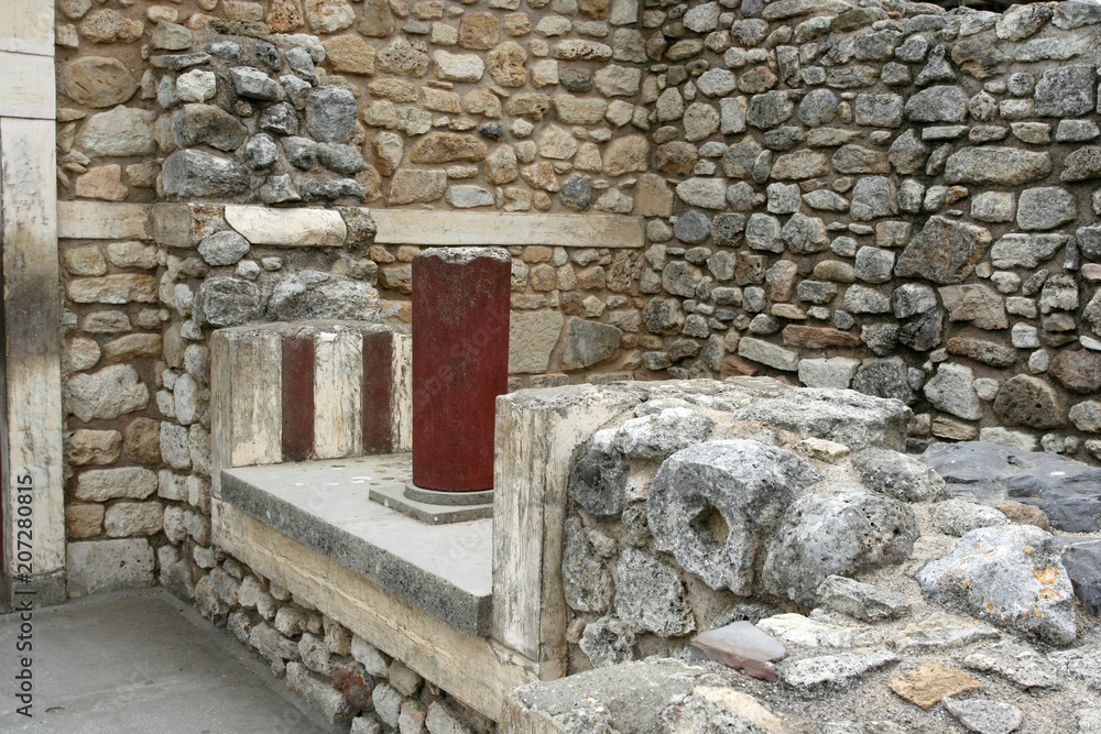 The part of the wall of the ancient building with the fragment of the red column in the Knossos on Crete island, Greece. The part of the wall of the ancient building with the fragment of the red column in the Knossos on Crete island, Greece.