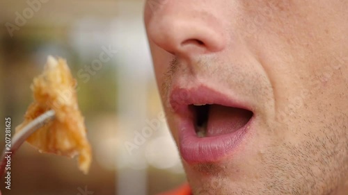 A man with an appetite eats a fork with delicious food, close-up. slow motion, 1920x1080, full hd