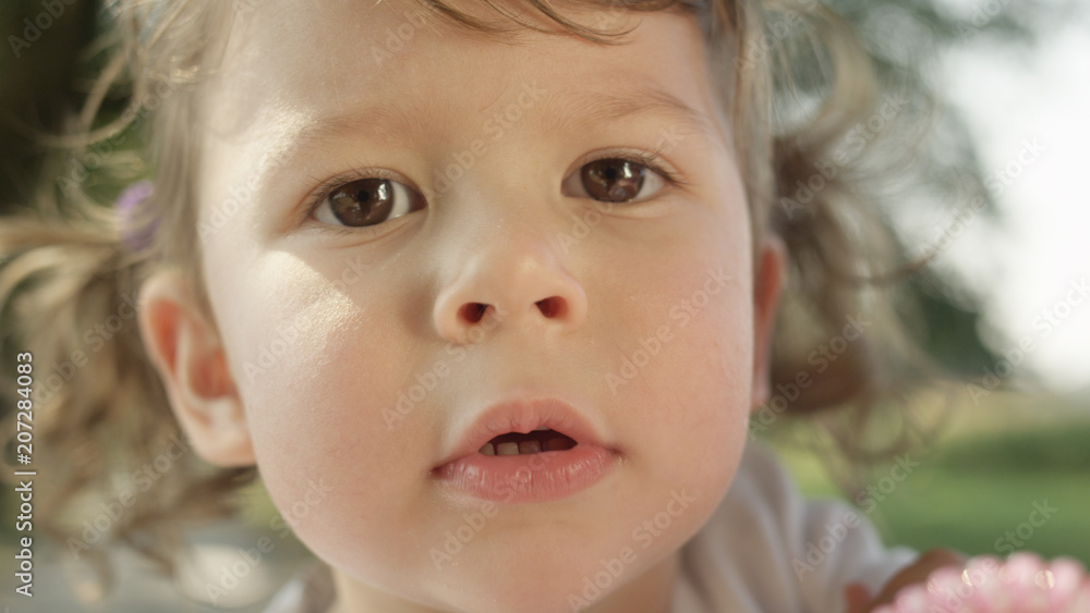 PORTRAIT, DOF: Lovely baby girl with cute brown pigtails looks into camera. PORTRAIT, DOF: Lovely baby girl with cute brown pigtails looks into camera.