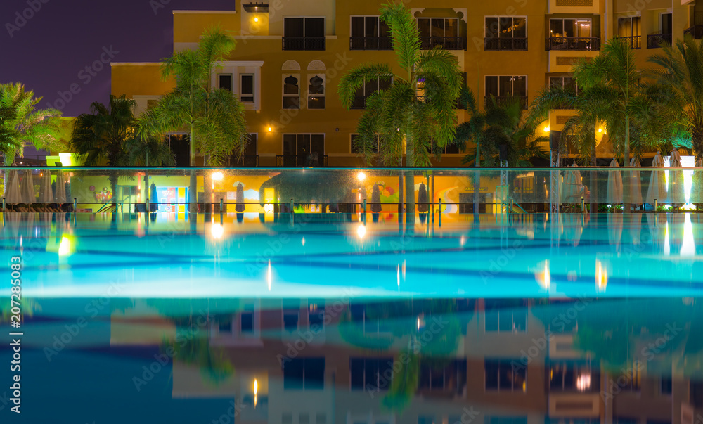 resort pool with palm trees at night,a beautiful scenic view