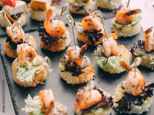 Fish, vegetable canapes on festival wedding table outdoor. Catering service
