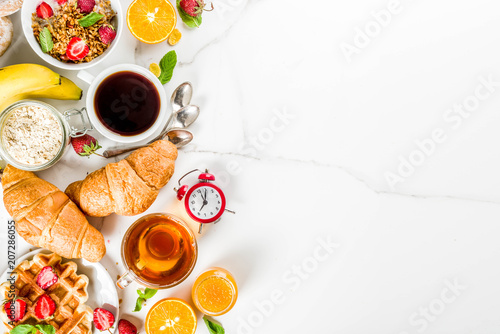 Healthy breakfast eating concept, various morning food - pancakes, waffles, croissant oatmeal sandwich and granola with yogurt, fruit, berries, coffee, tea, orange juice, white background