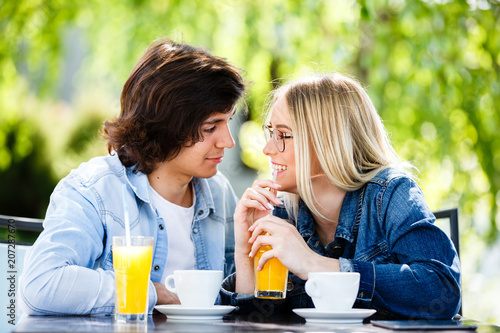 Young romantic couple spending time together - sitting in cafe's garden