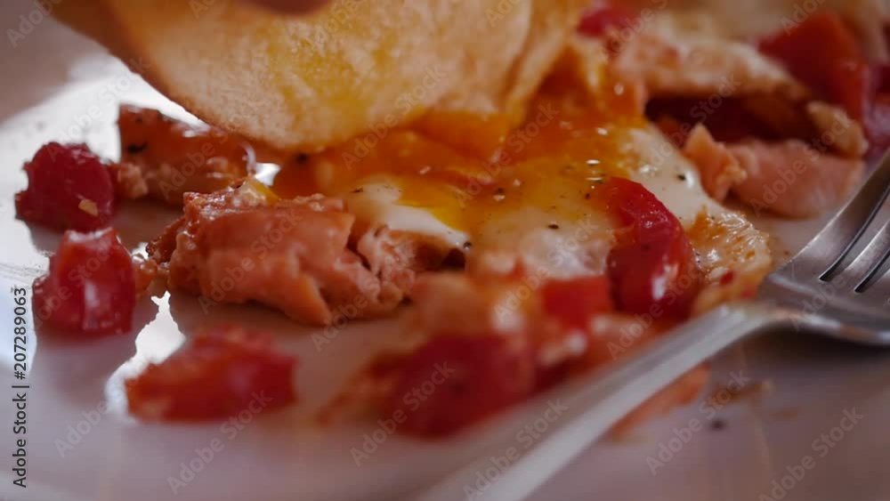 Dunk a slice of white bread in a hearty scrambled eggs, close-up. slow motion, 1920x1080, full hd Dunk a slice of white bread in a hearty scrambled eggs, close-up. slow motion, 1920x1080, full hd