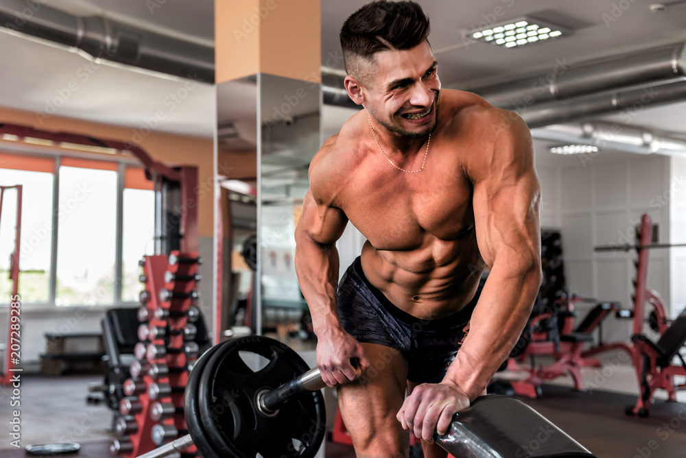 muscular man doing exersices in the gym muscular man doing exersices in the gym