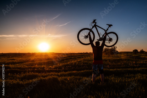 silhouette of a man with a bicycle