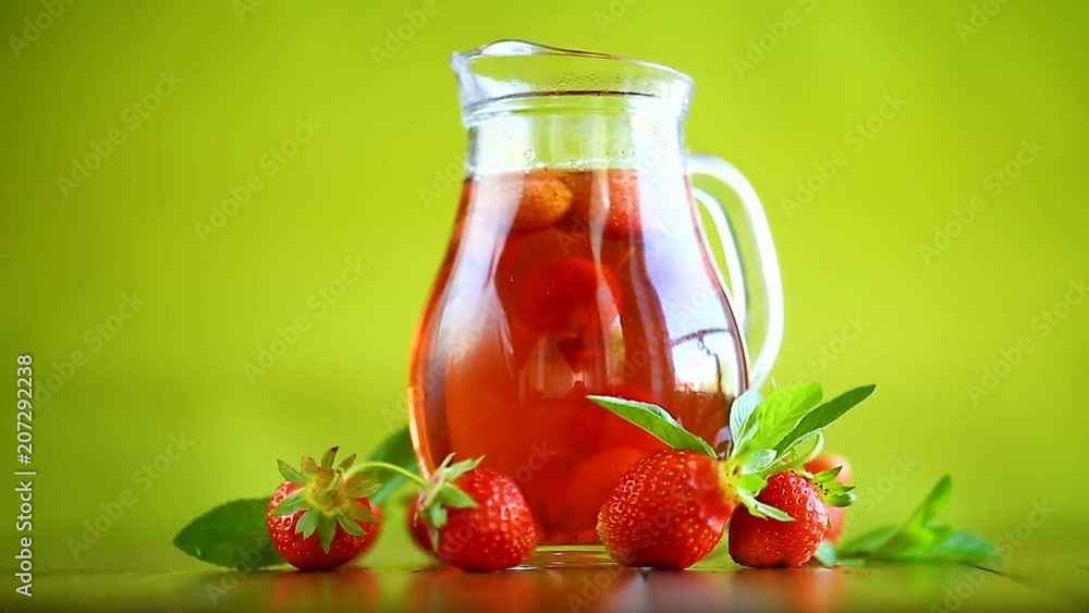 Sweet compote of ripe red strawberries in a glass decanter on a table Sweet compote of ripe red strawberries in a glass decanter on a table