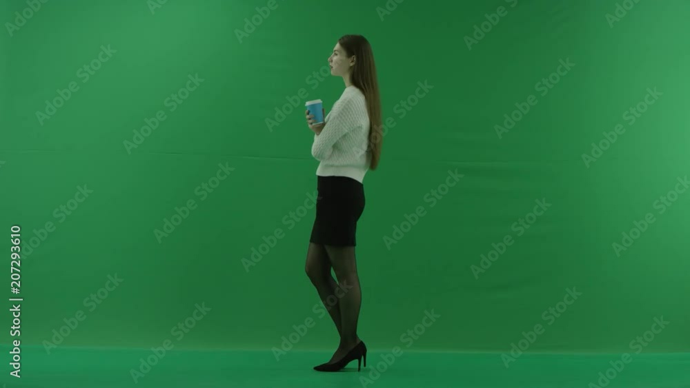 girl stands on her left side and drinks from a glass on the green screen girl stands on her left side and drinks from a glass on the green screen