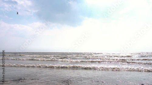 Small wave breaks at the beach. Footage. Waves of the sea in autumn. Slow motion photo