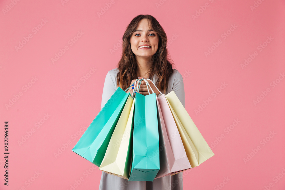 Happy young pretty woman shopaholic holding shopping bags.