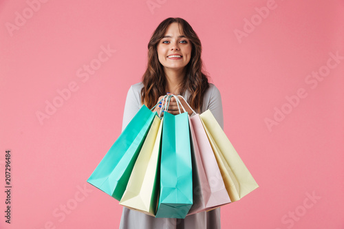 Happy young pretty woman shopaholic holding shopping bags.
