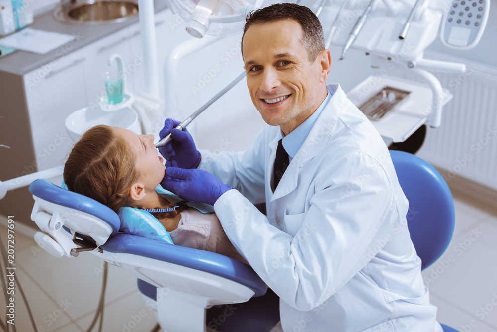 Doing checkup. Attractive brunette man feeling happiness while enjoying his job Doing checkup. Attractive brunette man feeling happiness while enjoying his job