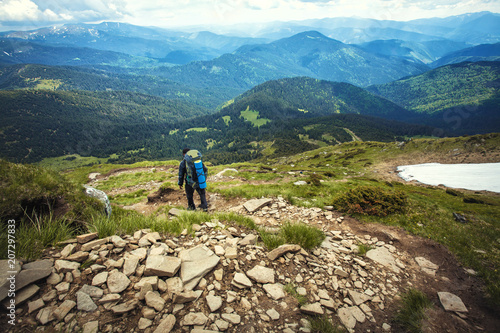 A tourist walks along a mountain meandering trail