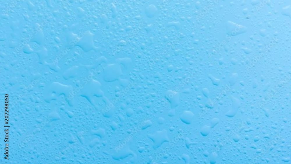 Blue surface with droplets and splashes of clear water. Rotate, slide the camera to the background. Blue surface with droplets and splashes of clear water. Rotate, slide the camera to the background.