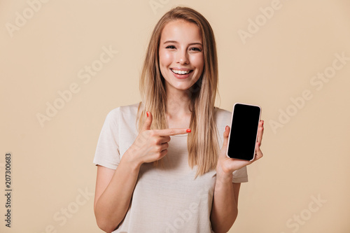 Portrait of a smiling casual girl pointing finger photo