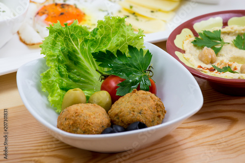 Traditional Arabic breakfast, lettuce, eggs, cheese, olives, and decorative vegetables, served on a plate, restaurant, service