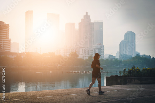 Female wearing blue clothes while running in a park in the sunset. Vintage tone