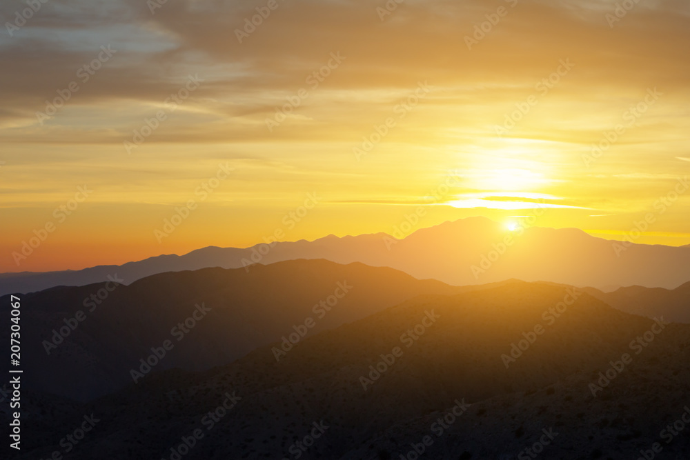 Sunlight shining over a colorful desert mountain landscape in California